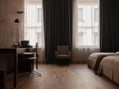 a hotel room with a desk and a bed and window at Grand Hotel in Łódź