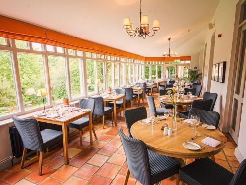 a restaurant with tables and chairs and windows at Eslington Villa in Gateshead