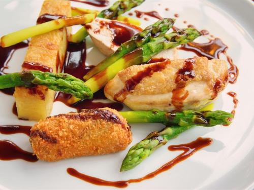 a plate of food with asparagus and meat with sauce at Eslington Villa in Gateshead