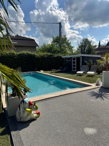 a swimming pool that is next to a house at Cozy apartment in Neuville-les-Dames