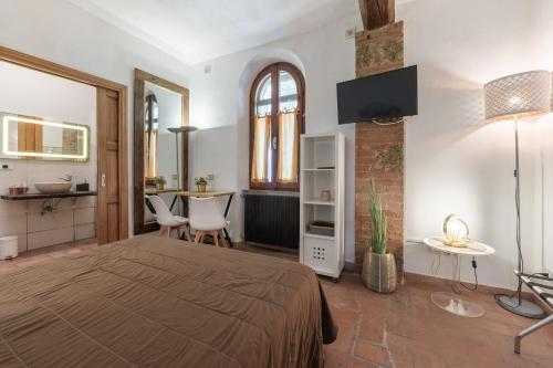 a bedroom with a bed and a table and a kitchen at Antico Podere Il Bugnolo in Poggibonsi