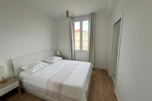 une chambre blanche avec un lit et une fenêtre dans l'établissement Aurélie - Charming 1Br Trottel Beach - by TGB, à Ajaccio