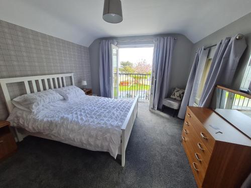 a bedroom with a white bed and a window at Castle Heights in Ardglass