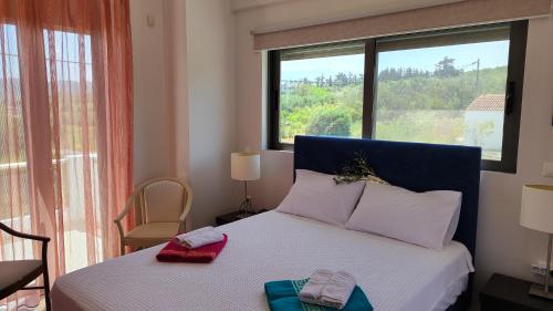 a bedroom with a bed with two towels on it at Villa Anastasia Sissy in Módhion