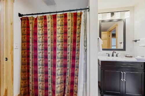 a bathroom with a shower curtain and a sink at The Grouse House in Greenville