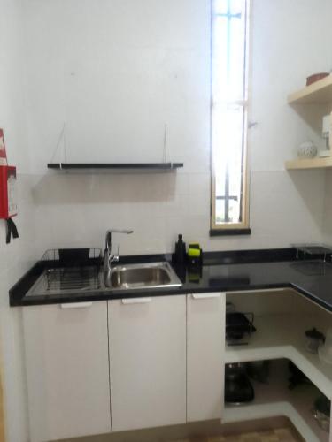 a white kitchen with a sink and a window at Refúgio do Douro Guest House in Bemposta