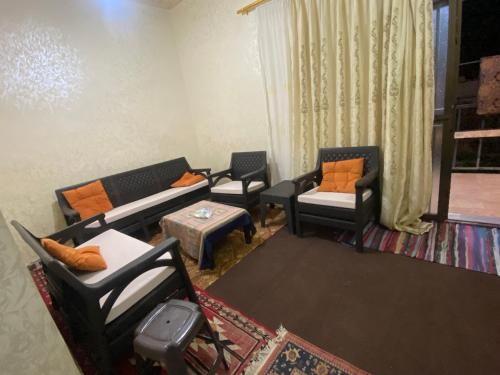 ein Wohnzimmer mit Sofas, Stühlen und einem Tisch in der Unterkunft Mohmad House in Jurf ad Darāwīsh