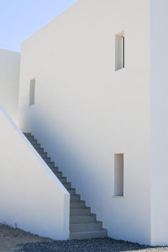 a staircase in a white wall with a stair case at Olive - Volia deluxe apartments in Adamas