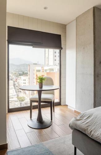 a dining room with a table and a large window at Departamentos exclusivos, equipados y amueblados en Torre Barrio Vergel in Monterrey