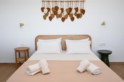 a bedroom with a bed with two towels on it at Olive - Volia deluxe apartments in Adamas