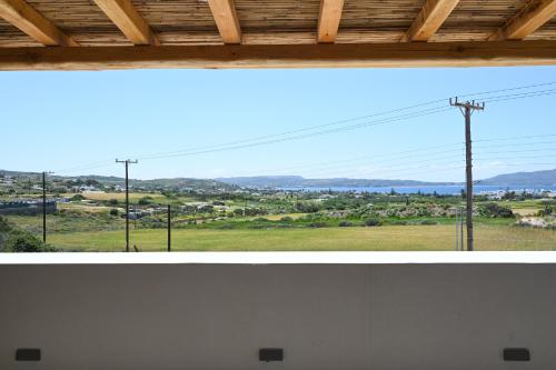 two pictures of a window with a view of a field at Olive - Volia deluxe apartments in Adamas