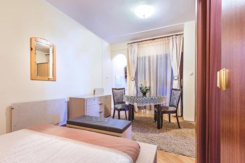 a bedroom with a bed and a table with chairs at Villa Roses Apartments & Wellness in Ičići