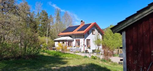 a small white house with a red roof at Charmigt äldre hus, laddbox 22 kw, 5 bil-minuter till bad in Strömstad