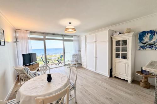 un salon avec une table, des chaises et une télévision dans l'établissement Évasion Marine - Vue mer imprenable 180, à Quiberon