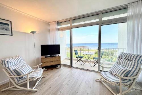 un salon avec deux chaises et une télévision dans l'établissement Évasion Marine - Vue mer imprenable 180, à Quiberon