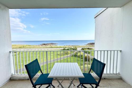 une table blanche et des chaises sur un balcon avec l'océan dans l'établissement Évasion Marine - Vue mer imprenable 180, à Quiberon