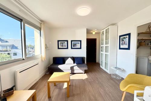 a living room with a couch and a window at Charmant Studio - Bourg & plages à pied in Larmor-Plage
