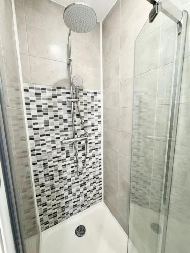 a shower with a glass door in a bathroom at Charmant T2 - Plein coeur de Quimperlé in Quimperlé