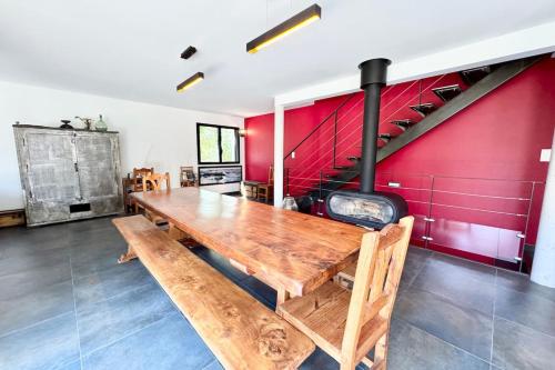 une salle à manger avec une table en bois et un mur rouge dans l'établissement Villa bord de mer Terrasse & accès plage à pied, à Guidel