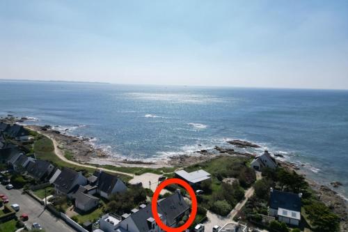 une maison avec un cercle rouge devant l'océan dans l'établissement Spacieuse maison au bord des plages, à Ploemeur