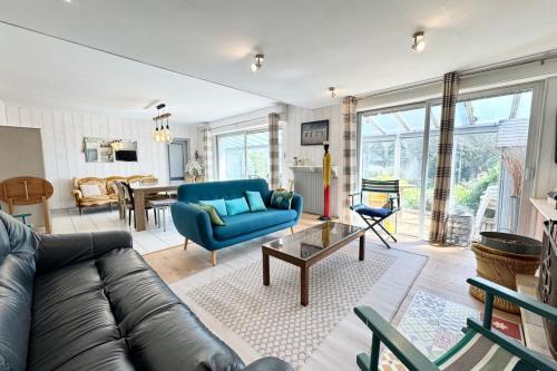 un salon avec un canapé bleu et une table dans l'établissement Spacieuse maison au bord des plages, à Ploemeur