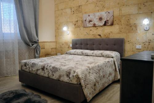 a bedroom with a bed and a stone wall at Casa vacanze da Pino A in Torchiarolo