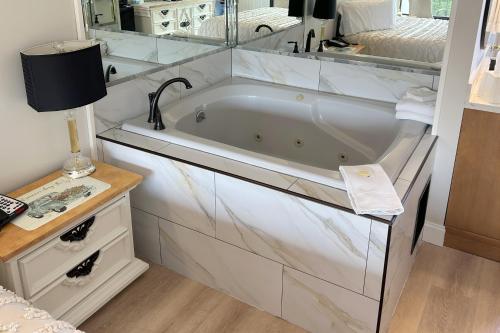 a bathroom with a bath tub with a sink at Rivergate Mountain Lodge in Pigeon Forge