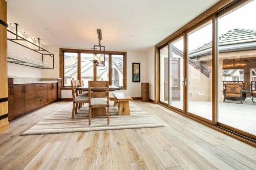 a dining room with a table and chairs and large windows at Luxe 4 Bedroom Beaver Creek Lodge Condo With Ski In, Ski Out Access in Beaver Creek