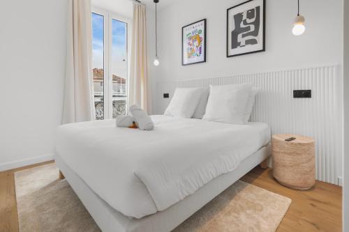 une chambre avec un grand lit blanc avec une fenêtre dans l'établissement Magnifique appartement centre-ville - Palais 5min, à Cannes