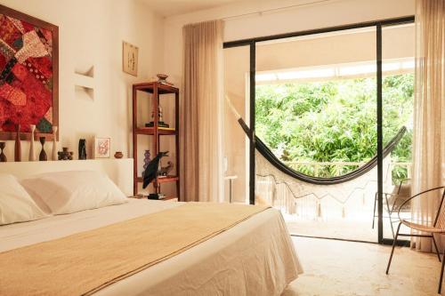 a bedroom with a bed and a large window at Hotel Hukumeizi Minca in Minca