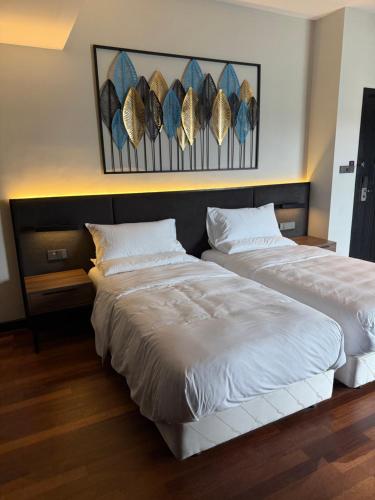 two beds sitting next to each other in a bedroom at Avani Sepang Goldcoast Resort in Tanjong Sepat