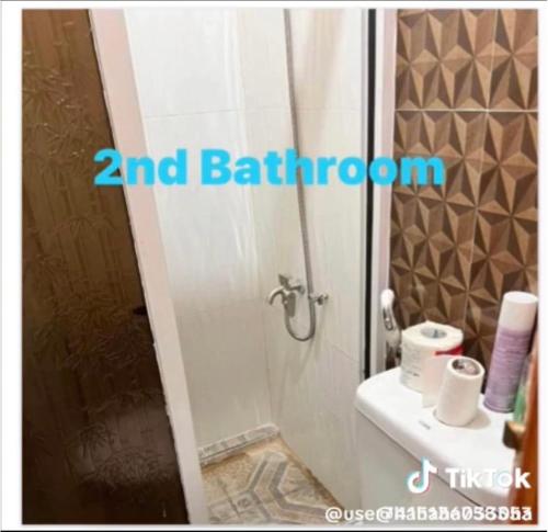 a bathroom with a shower and a toilet and a sink at DC Travellers Inn in Malolos