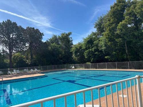 une grande piscine bleue avec des arbres en arrière-plan dans l'établissement Studio plein centre de Saint-Tropez avec Parking gratuit, à Saint-Tropez