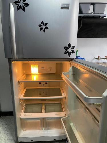 an empty refrigerator with its door open in a kitchen at Casa Alameda in Mexico City