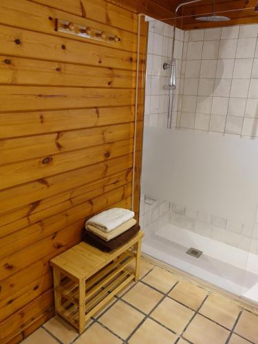 a bathroom with a shower and a wooden wall at Chalet con piscina privada in Borriol