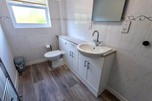 a bathroom with a sink and a toilet at Modern Double Room with Broadband, Private TV and seating area - Room 3 in Solihull