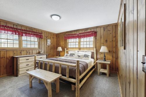 a bedroom with a large bed in a room with wooden walls at Stone Lake View in Manitowish Waters