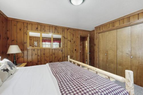 a bedroom with wooden walls and a large bed at Stone Lake View in Manitowish Waters