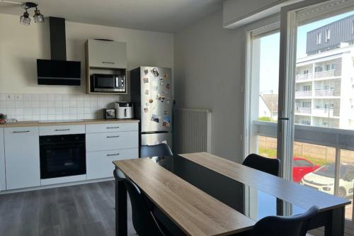 une cuisine avec une table et un réfrigérateur dans l'établissement Apt 1 bedroom 10 min from the historic center, à Saint-Malo