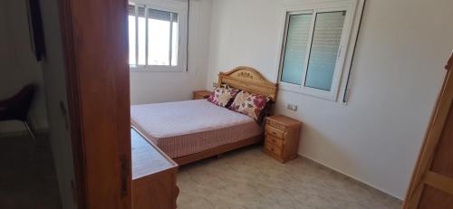 a small bedroom with a small bed and a window at Duplex in diki-KSARSGHIR with panoramic terrace in Tangier