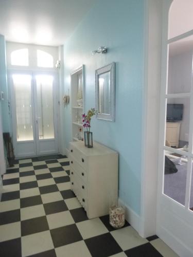 La salle de bains est pourvue d'une commode blanche et d'un miroir. dans l'établissement L'Ermitage, à Pornic