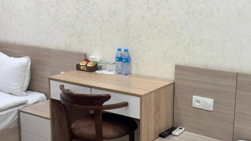 a small desk with a chair in a hotel room at Chinor Hotel Fergana in Fergana
