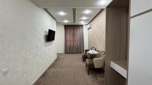 a waiting room with a table and chairs at Chinor Hotel Fergana in Fergana