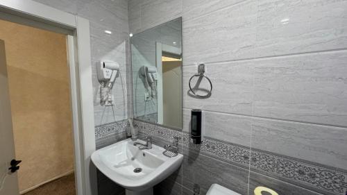 a bathroom with a sink and a mirror at Chinor Hotel Fergana in Fergana