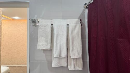 a group of towels hanging on a rack in a bathroom at Chinor Hotel Fergana in Fergana