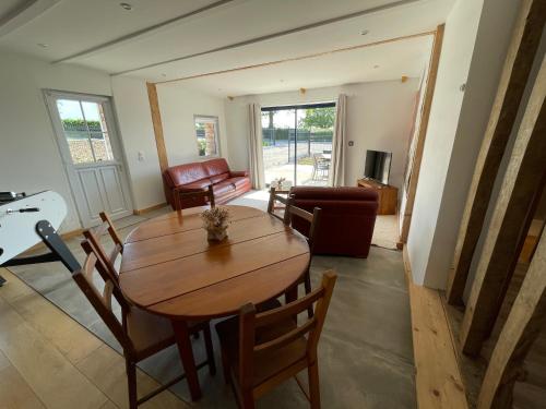 un salon avec une table et des chaises en bois dans l'établissement Gîte chez Line & Mon, à Bournonville