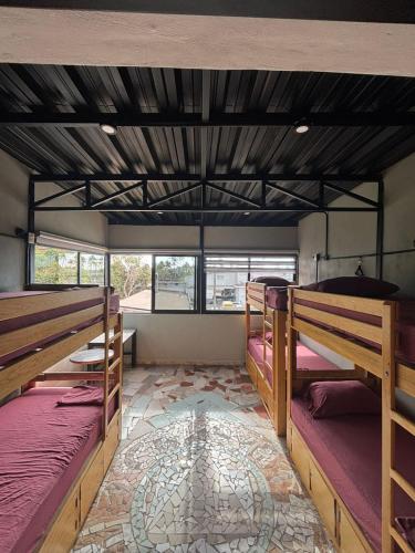 a room with three bunk beds in a building at Canova Hostel & Pizza in Puerto Vallarta