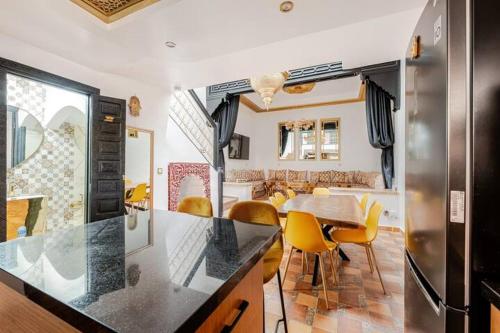 une cuisine et une salle à manger avec une table et des chaises jaunes dans l'établissement 16 Riads, à Marrakech