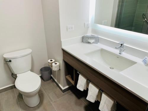 a white bathroom with a toilet and a sink at Holiday Inn Express - Guadalajara Vallarta Poniente by IHG in Guadalajara