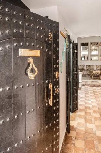 une rangée de casiers noirs dans une pièce avec un mur dans l'établissement 16 Riads, à Marrakech